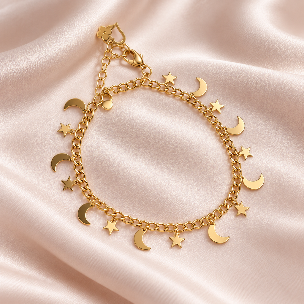 Golden Moon & Stars gold-tone charm bracelet with dangling crescent and star charms on blush satin