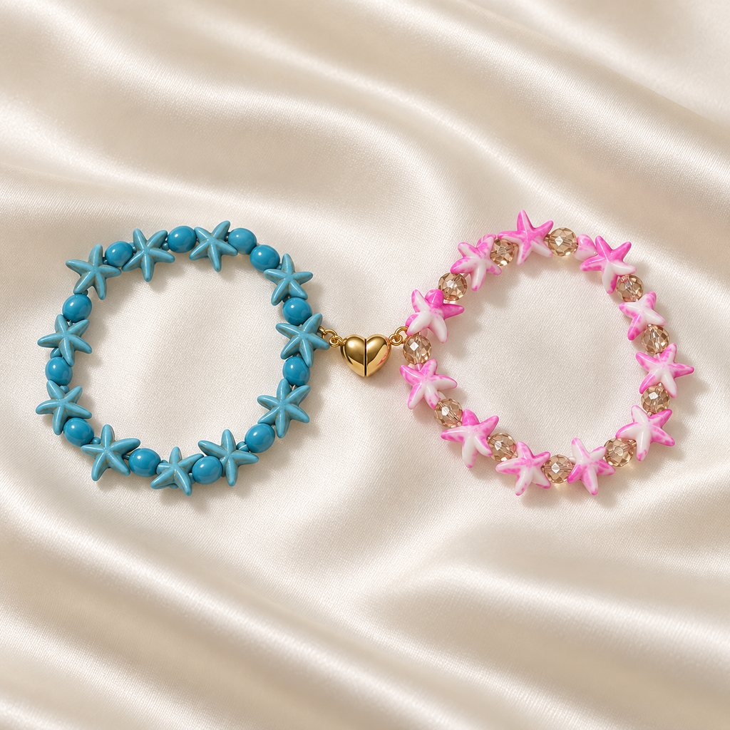 Starfish Friendship Bracelet Pair on pale champagne satin: turquoise-blue starfish bracelet and pink-and-white starfish bracelet connected by a gold-tone split heart.