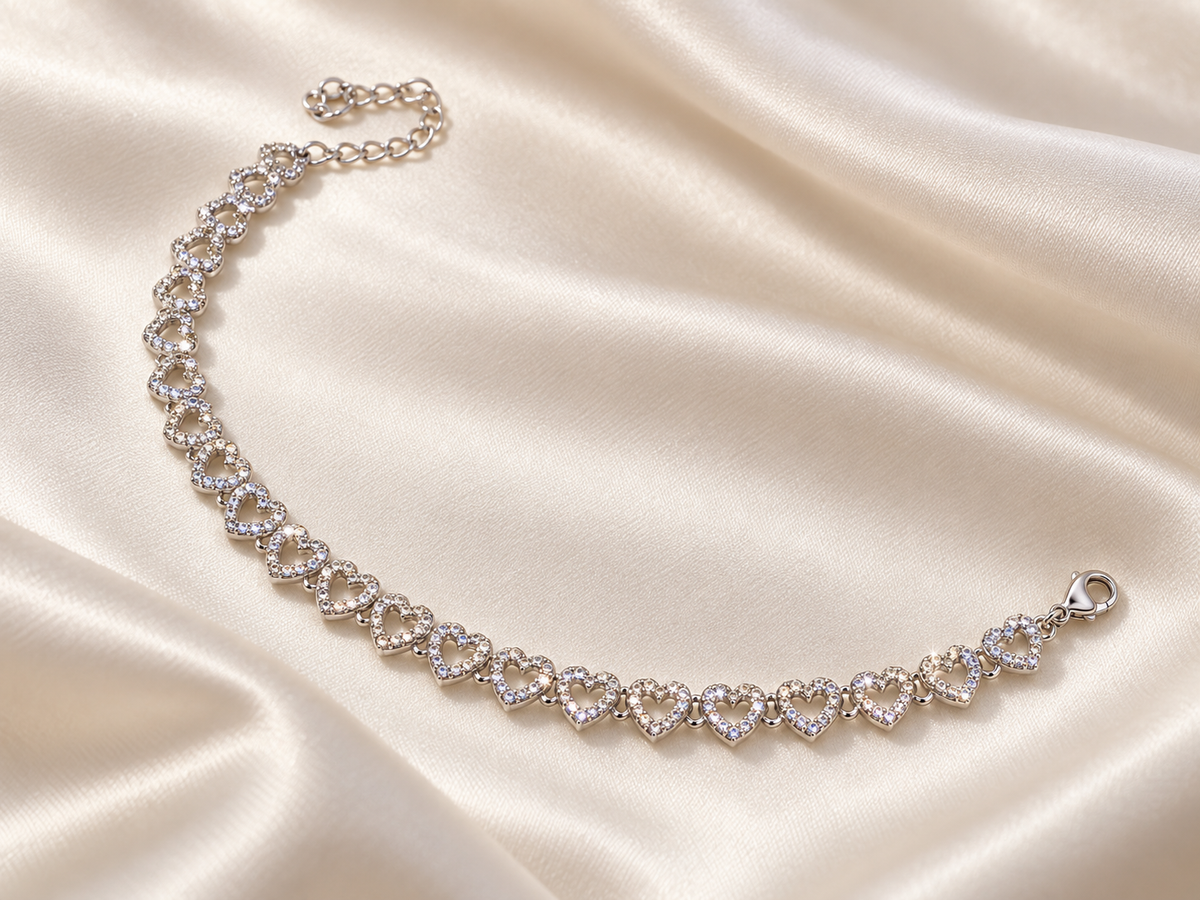 Silver-tone open heart link bracelet with clear sparkle on ivory satin