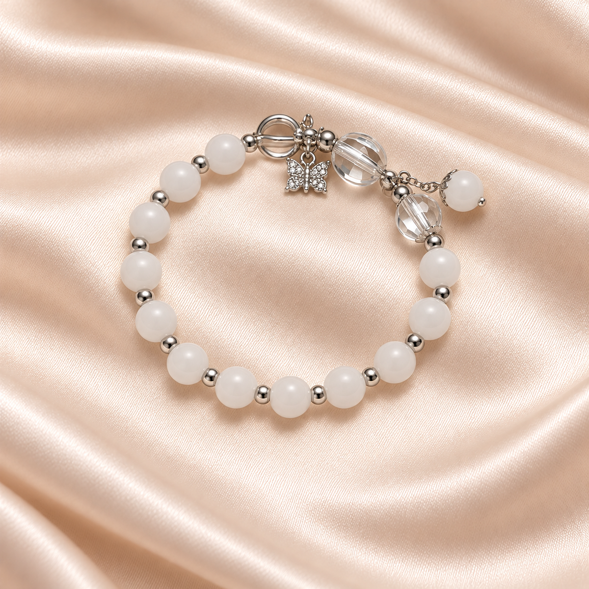 Snow White Bead Bracelet on pale champagne satin, with opaque white beads, silver-tone spacers, clear accent beads and a butterfly charm.