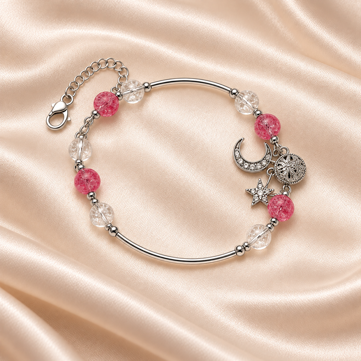 Pink Moon & Star Bracelet on pale champagne satin, with silver-tone curved bars, textured pink and clear beads, celestial charms and extender visible.
