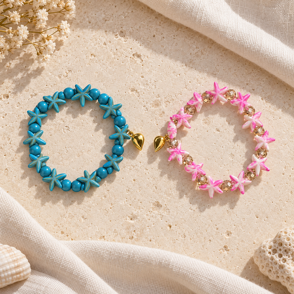 Two separate Starfish Friendship Bracelets on ivory stone and linen, one blue and one pink, each with a half of the gold-tone heart.