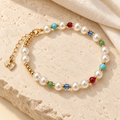 Color Pop Pearl-Style Bracelet styled on beige stone with white pearl-style beads and blue, green, red and turquoise accents.