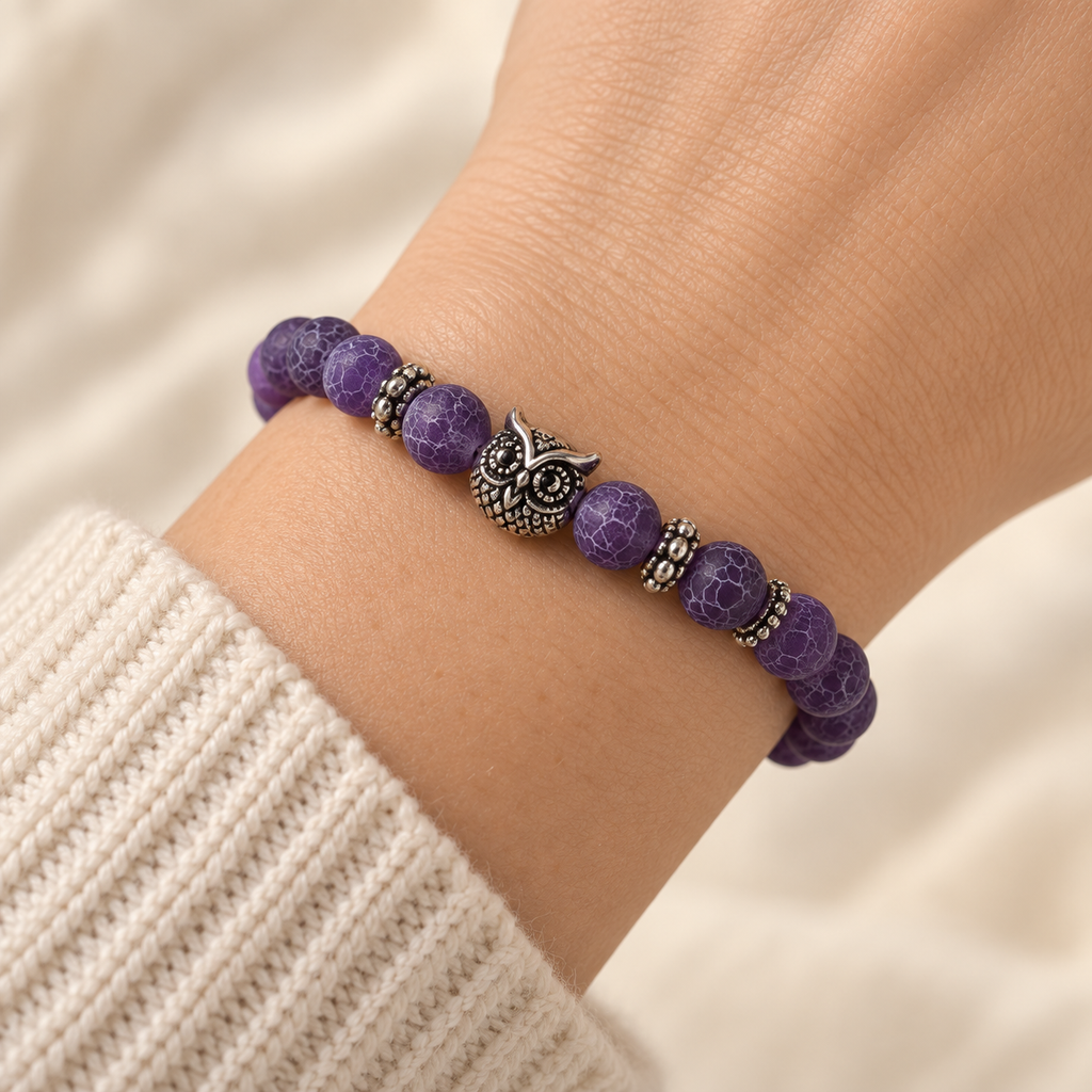 Close-up of the Purple Owl Bead Bracelet worn snugly around a wrist, with the silver-tone owl centered above the purple crackle-pattern beads.