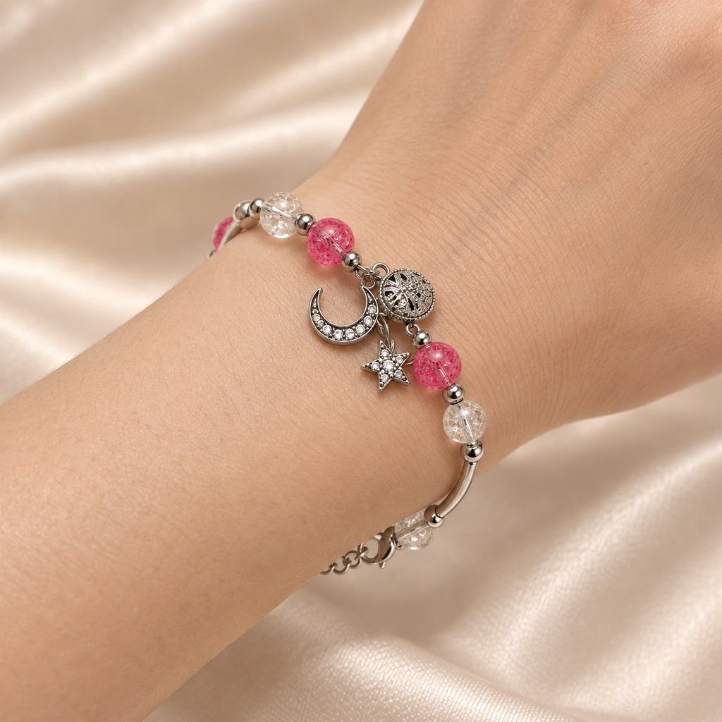 Close-up of the Pink Moon & Star Bracelet worn snugly around a wrist, showing the textured pink and clear beads and silver-tone celestial charms.