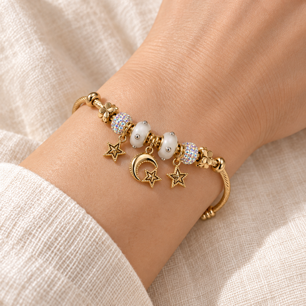 Close-up of the Moon & Star Bead Cuff fitted snugly around a wrist, showing white beads, sparkling accents and dangling moon-and-star charms.
