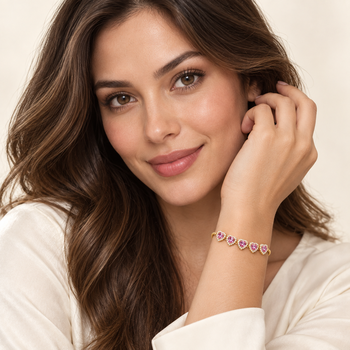 Portrait of a woman showing her full face and the Blush Heart Slider Bracelet snugly worn on her raised wrist, with five pink hearts across the front.