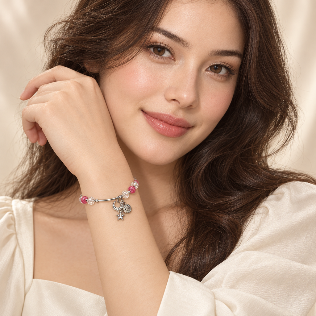 Full-face model portrait wearing the Pink Moon & Star Bracelet snugly around a raised wrist, with pink and clear beads and silver-tone celestial charms visible.