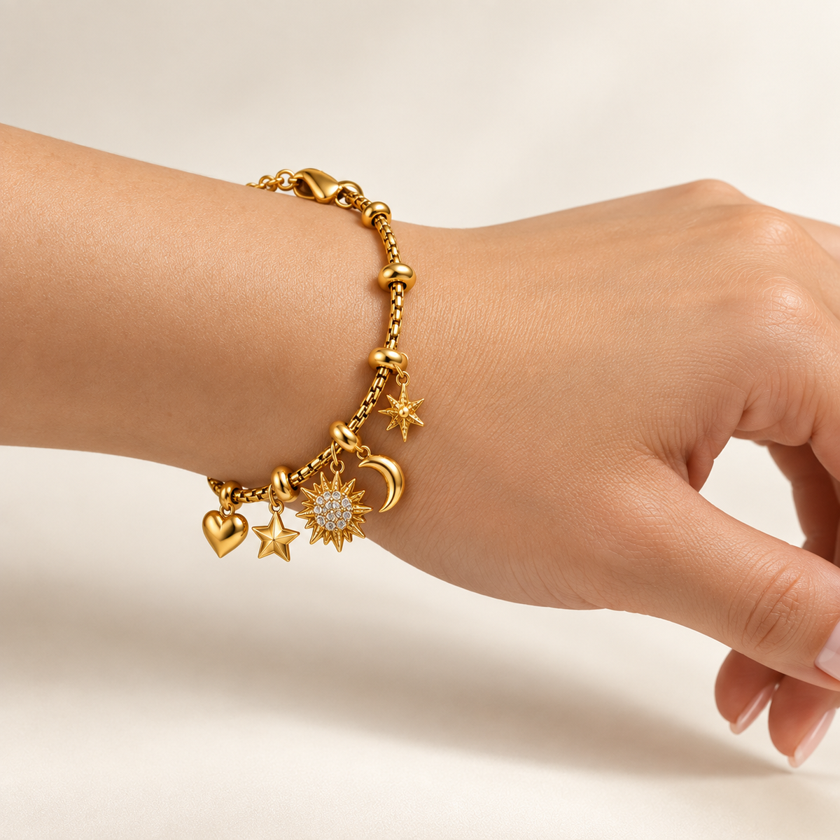 Side view of the gold-tone celestial charm bracelet clasped snugly around a wrist