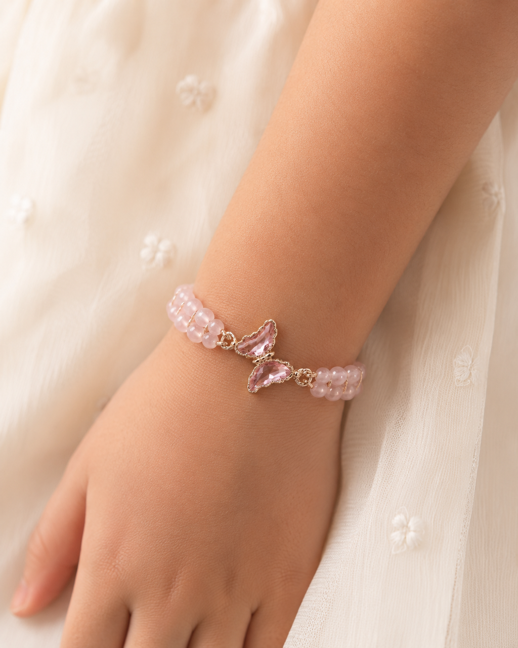 Blush Butterfly Bracelet with pink beads and butterfly centerpiece worn on wrist.