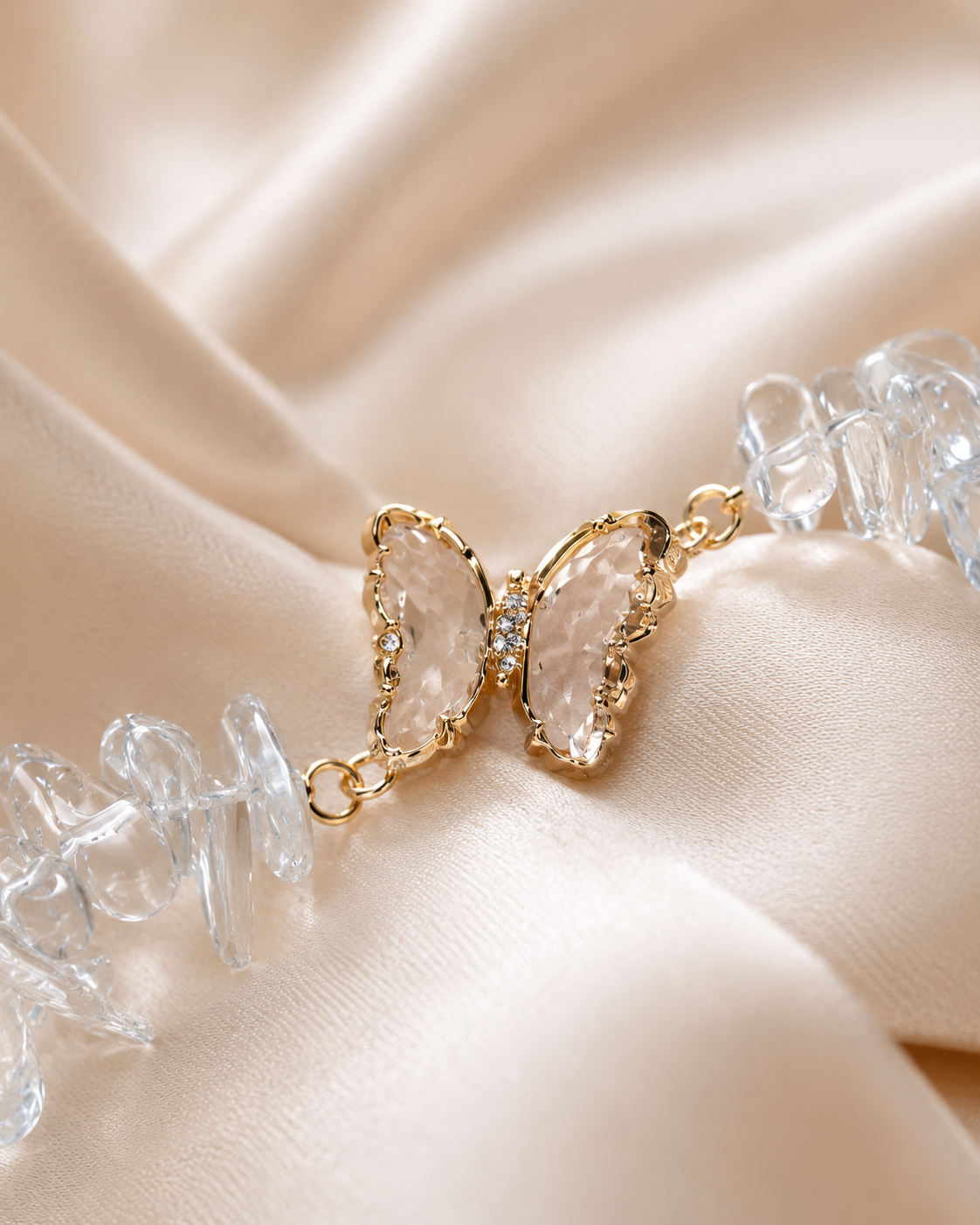 Close-up of clear butterfly centerpiece with gold details and sparkling clear crystal beads.