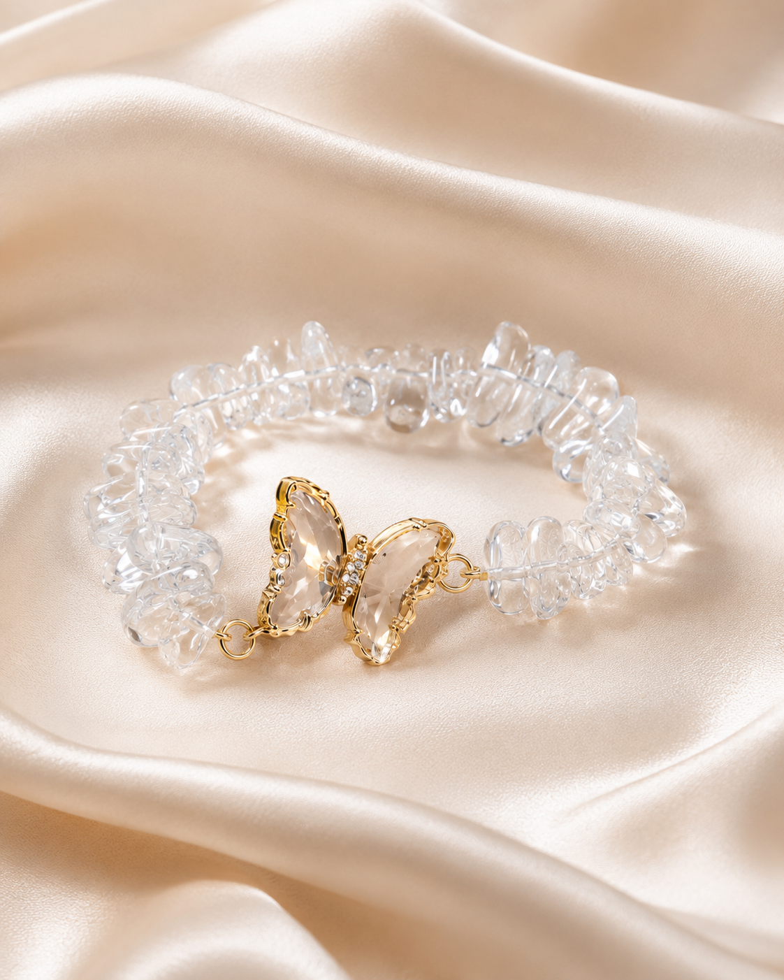Crystal Butterfly Bracelet with clear crystal beads, clear butterfly centerpiece, and delicate gold accents on satin fabric.
