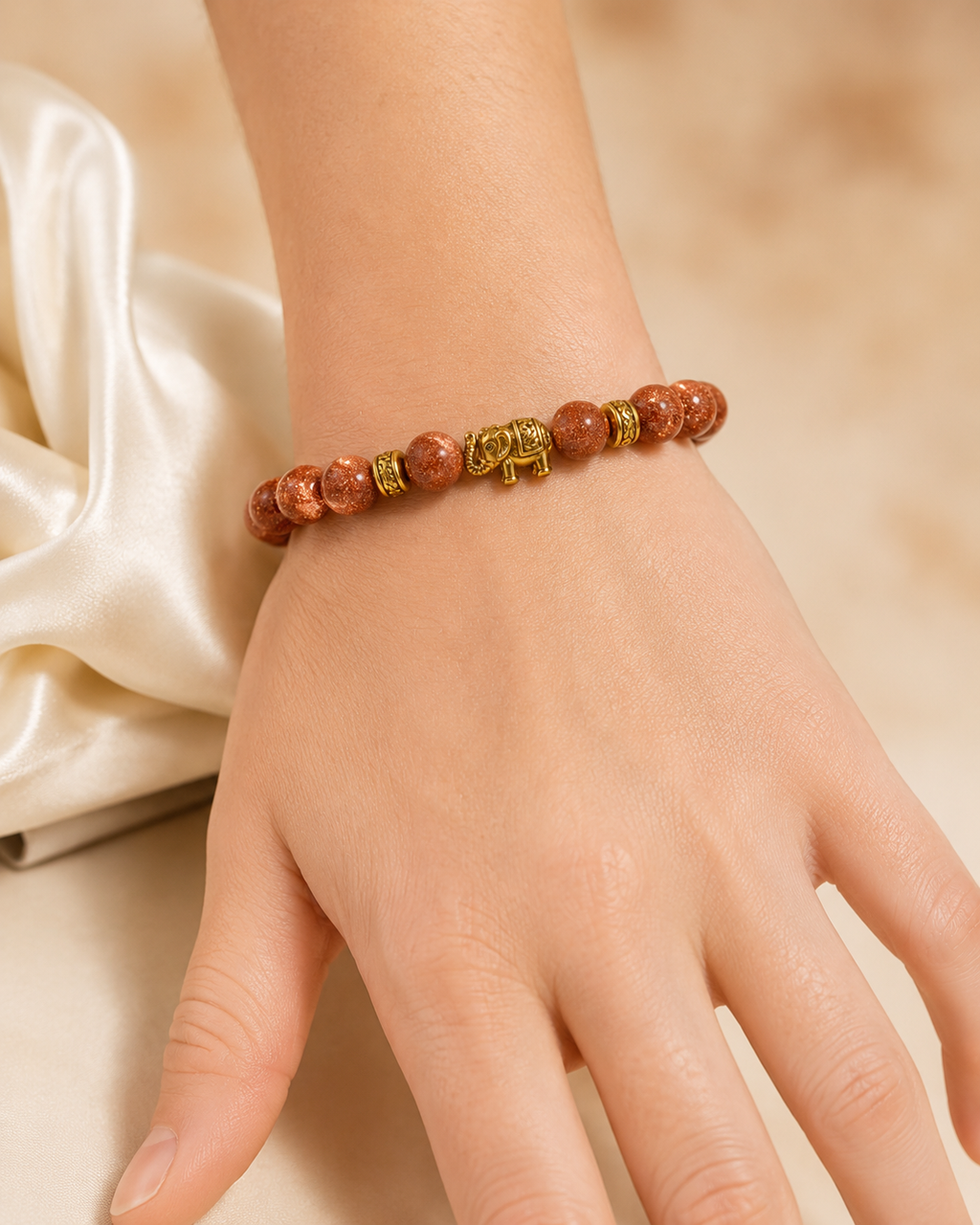 Golden Elephant Bracelet with copper-brown beads and gold elephant charm worn on wrist.