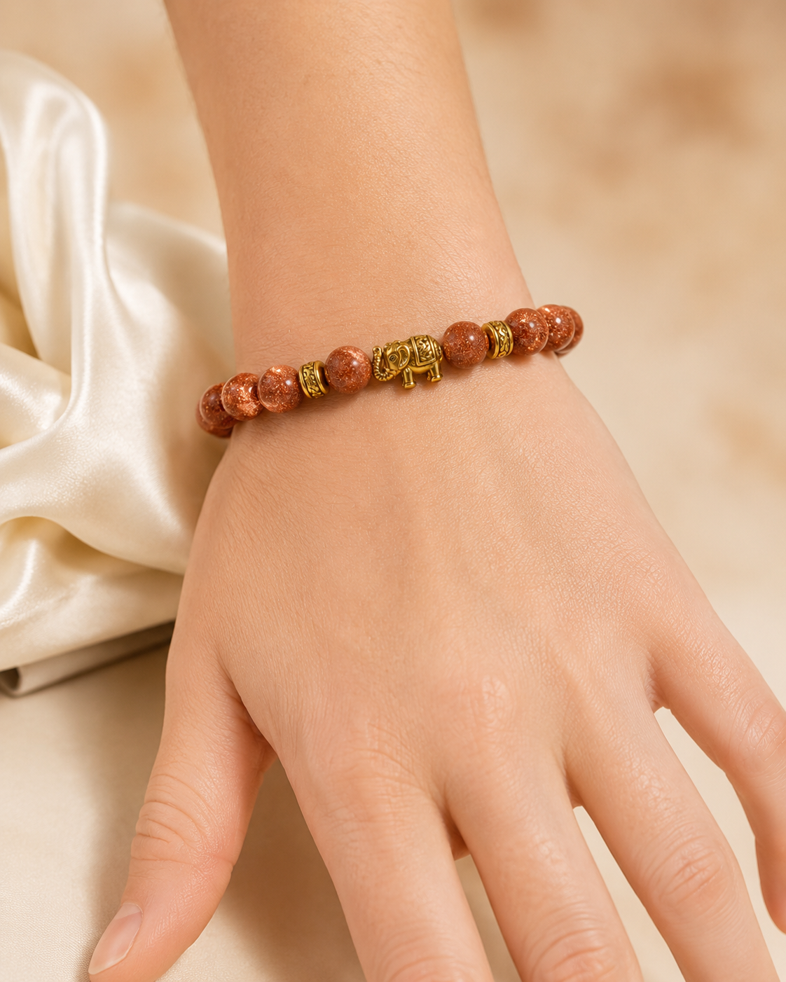 Golden Elephant Bracelet with copper-brown beads and gold elephant charm worn on wrist.