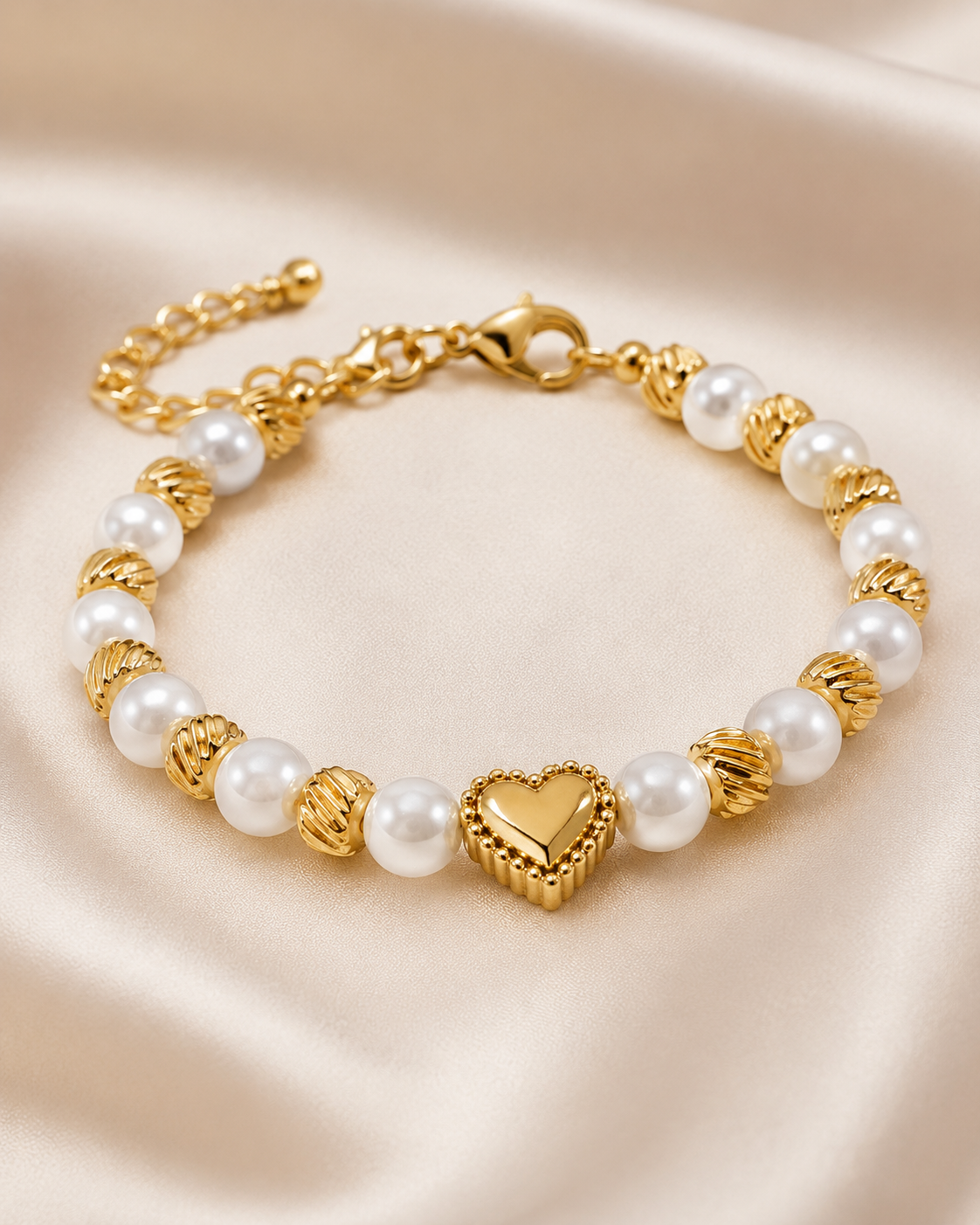 Close-up of Golden Pearl Heart Bracelet showing gold heart centerpiece, white pearl beads, and detailed gold swirl spacers.