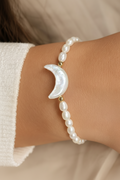 Ohana Collection freshwater pearl bracelet with crescent moon centerpiece and signature charm worn on hand.
