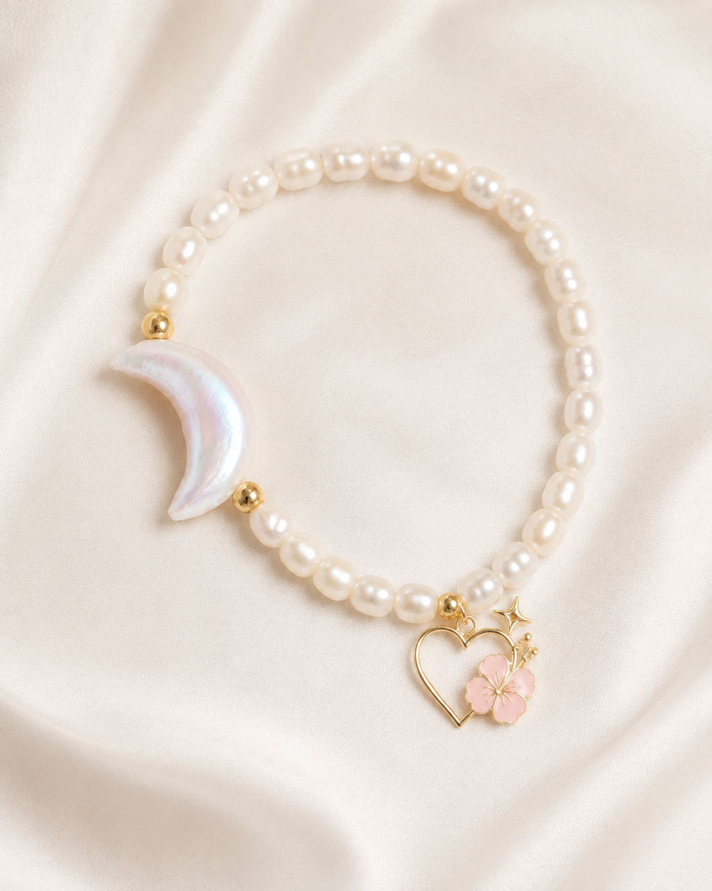 Moonlit Pearl Bracelet with freshwater pearls, iridescent crescent moon, gold spacer beads, and Ohana charm on ivory fabric.