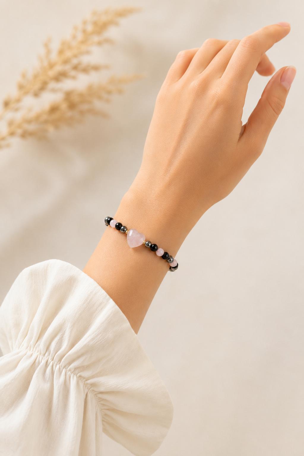 Zoomed-out lifestyle image of Rose Shadow Heart Bracelet worn on wrist with soft neutral styling.

