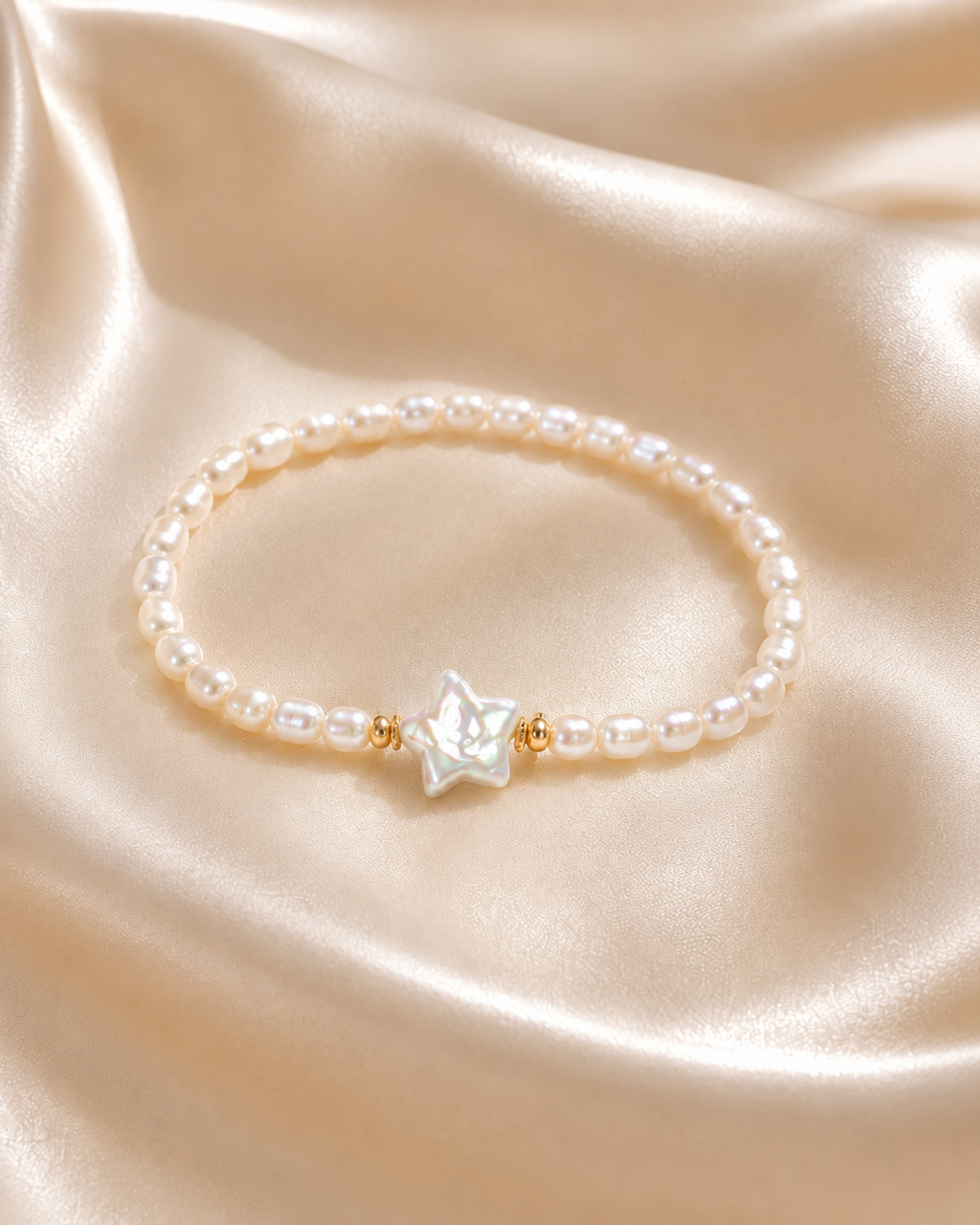 Starlight Pearl Bracelet with round pearl beads, iridescent star centerpiece, and small gold accent beads on satin fabric.
