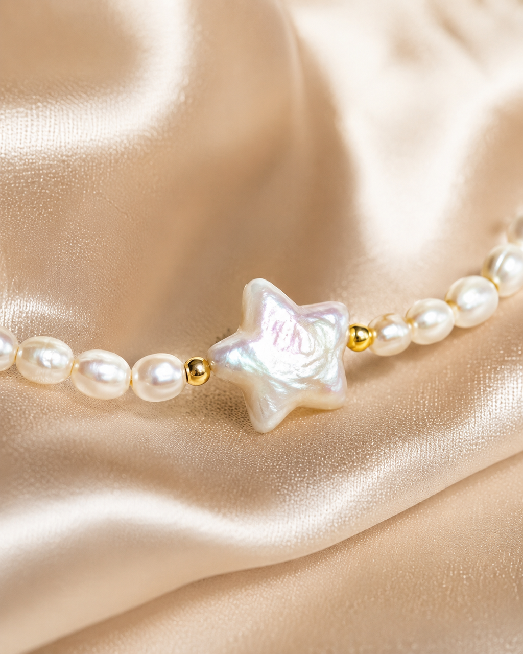 Close-up of iridescent star centerpiece with round pearl beads and small gold accent details.
