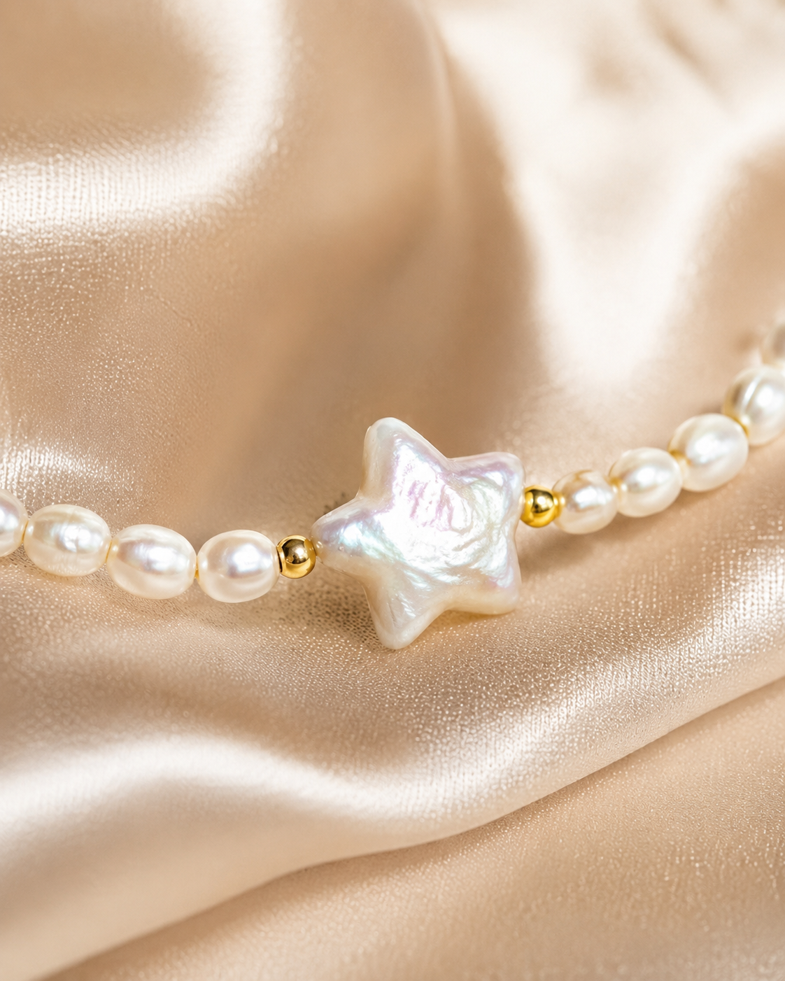 Close-up of iridescent star centerpiece with round pearl beads and small gold accent details.
